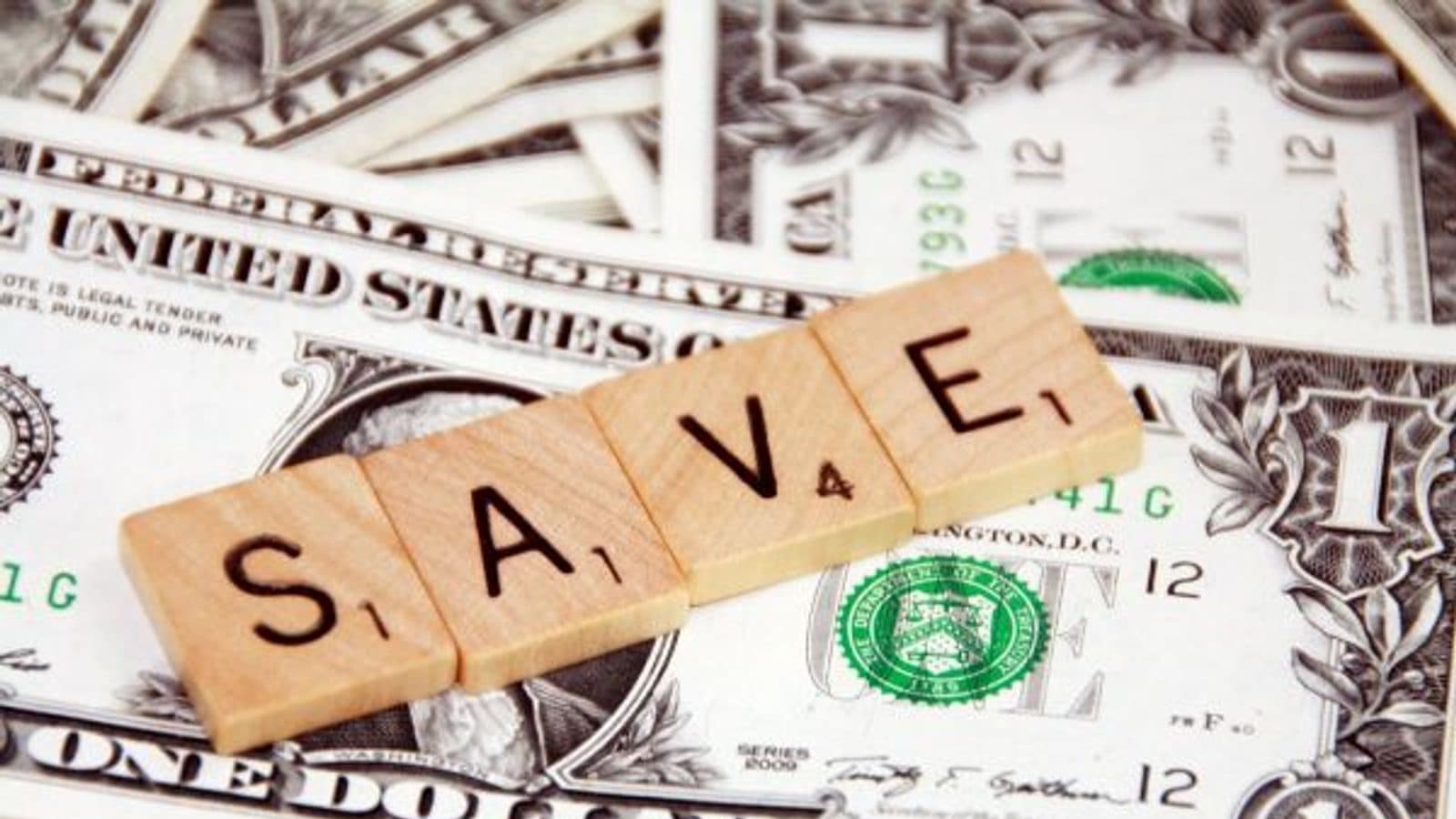 Un étudiant sourit en gérant son budget devant son ordinateur