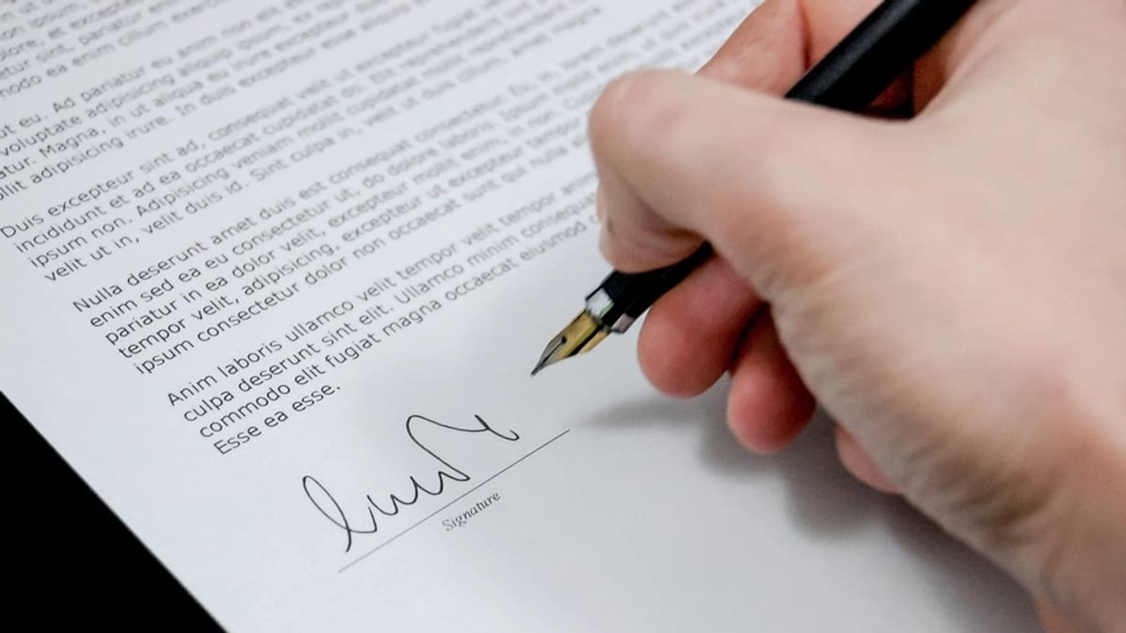 Un jeune alternant assis à un bureau, relisant son contrat de travail avant d'engager une procédure de sortie