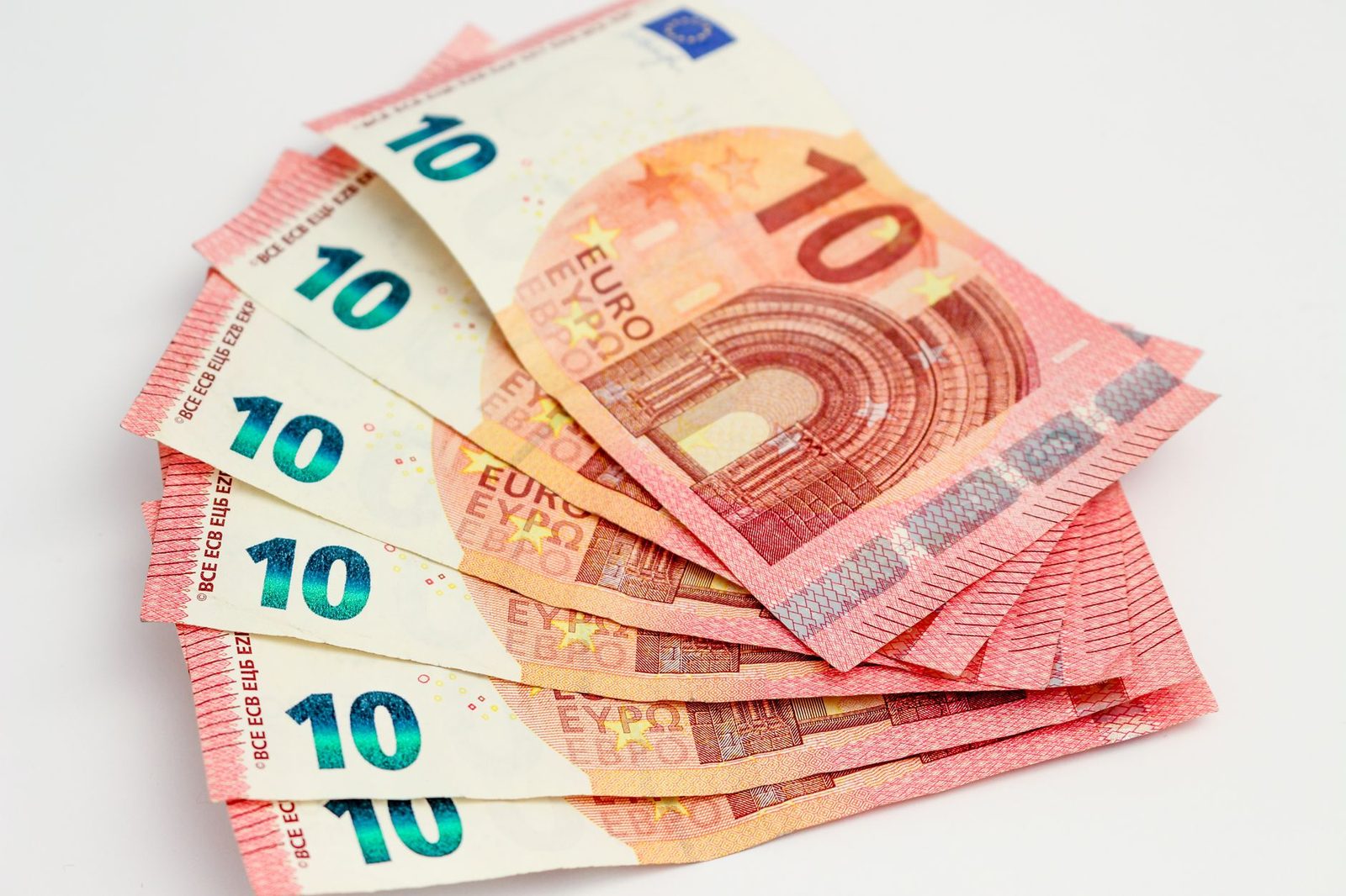 Plusieurs billets de 10 euros disposés en éventail sur un fond blanc