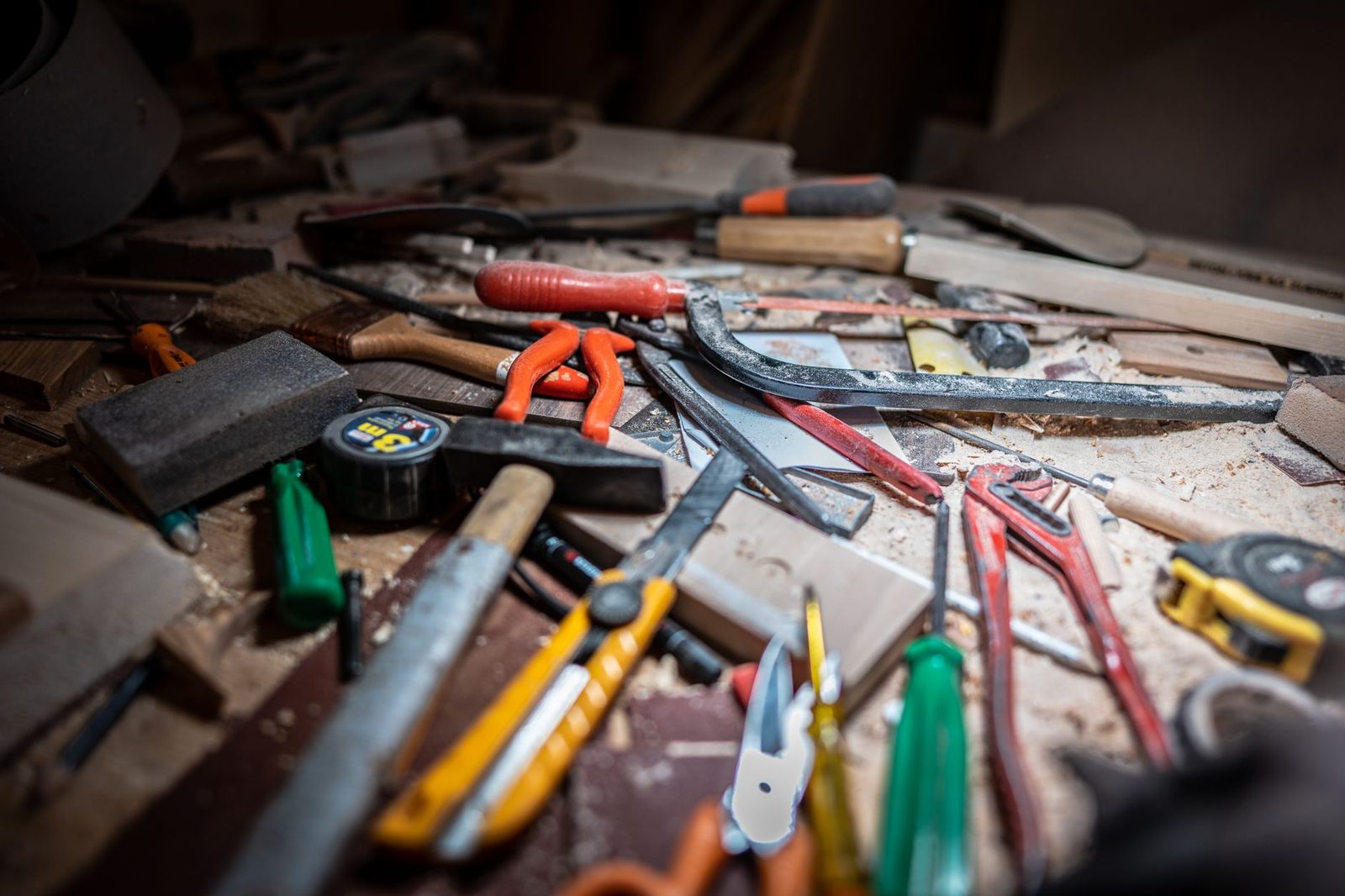 Outils de menuiserie éparpillés sur un établi couvert de sciure dans un atelier