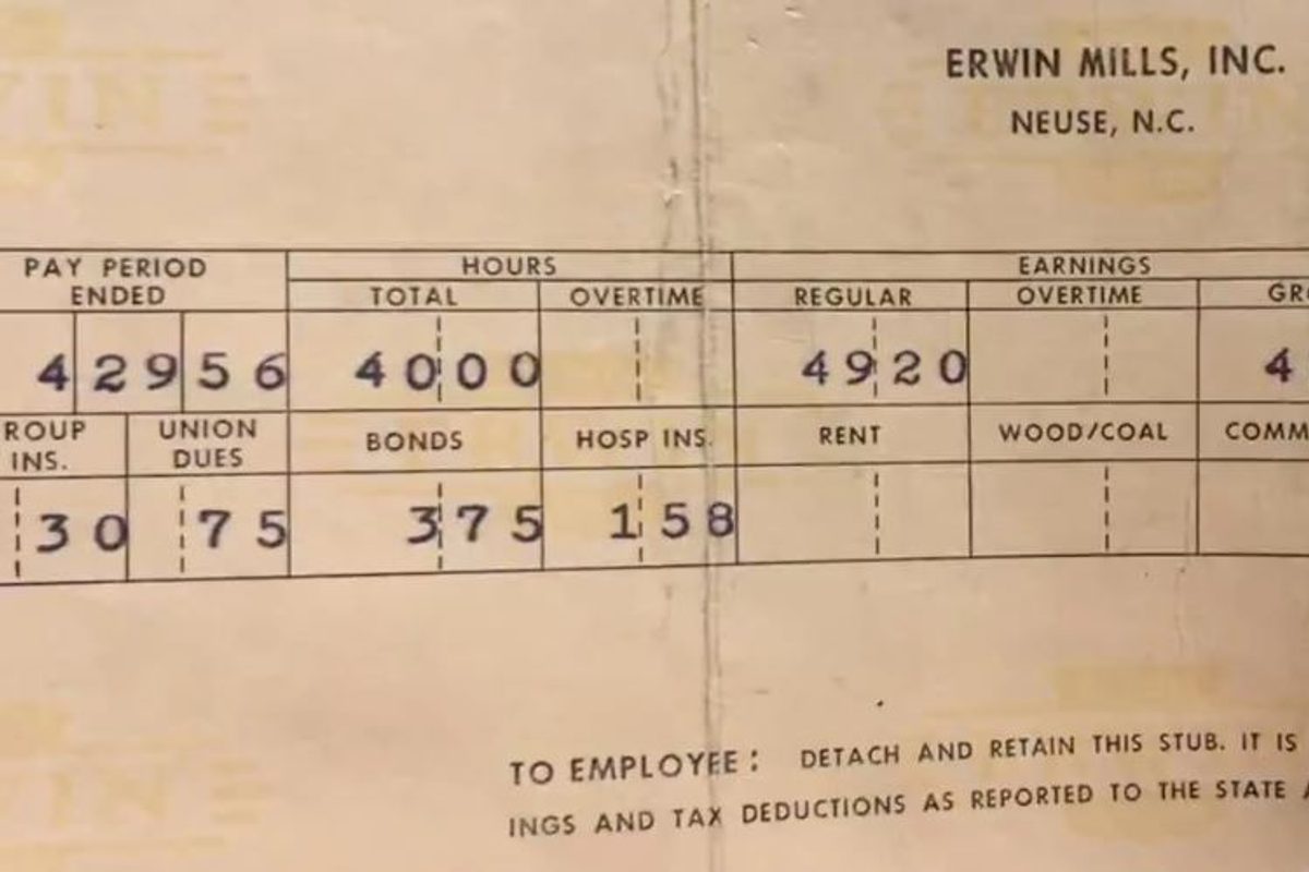 Une personne compare ses bulletins de salaire et sa prime d'activité sur un ordinateur portable, illustrant le calcul du complément de revenu pour un alternant en 2026