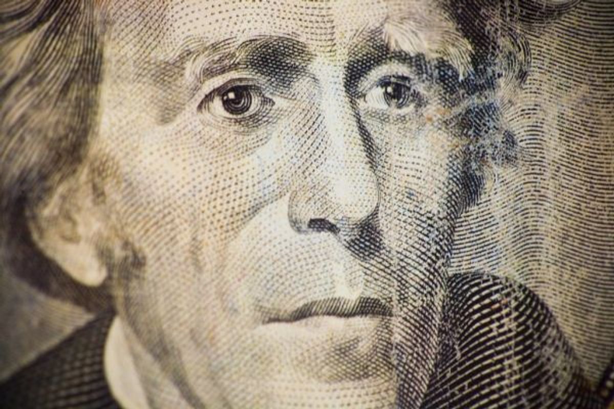 Pièces de monnaie et billets en euros sur un bureau avec un ordinateur ouvert, illustrant la revalorisation du SMIC et son impact sur le salaire des alternants