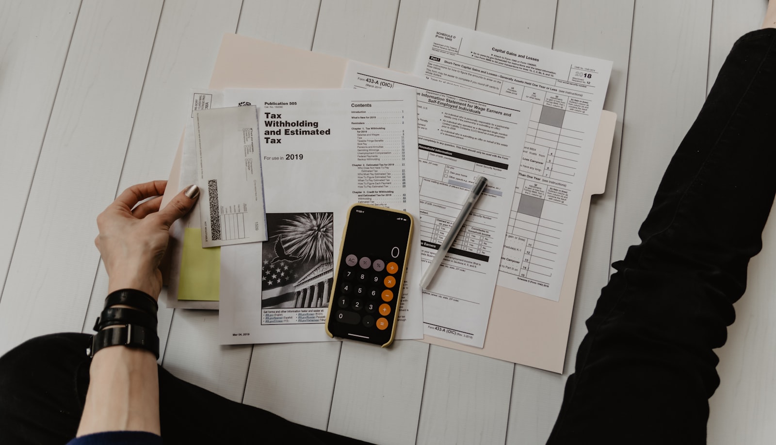 Desk with calculator, laptop and work documents, illustrating the calculation and allocation of the apprenticeship tax balance