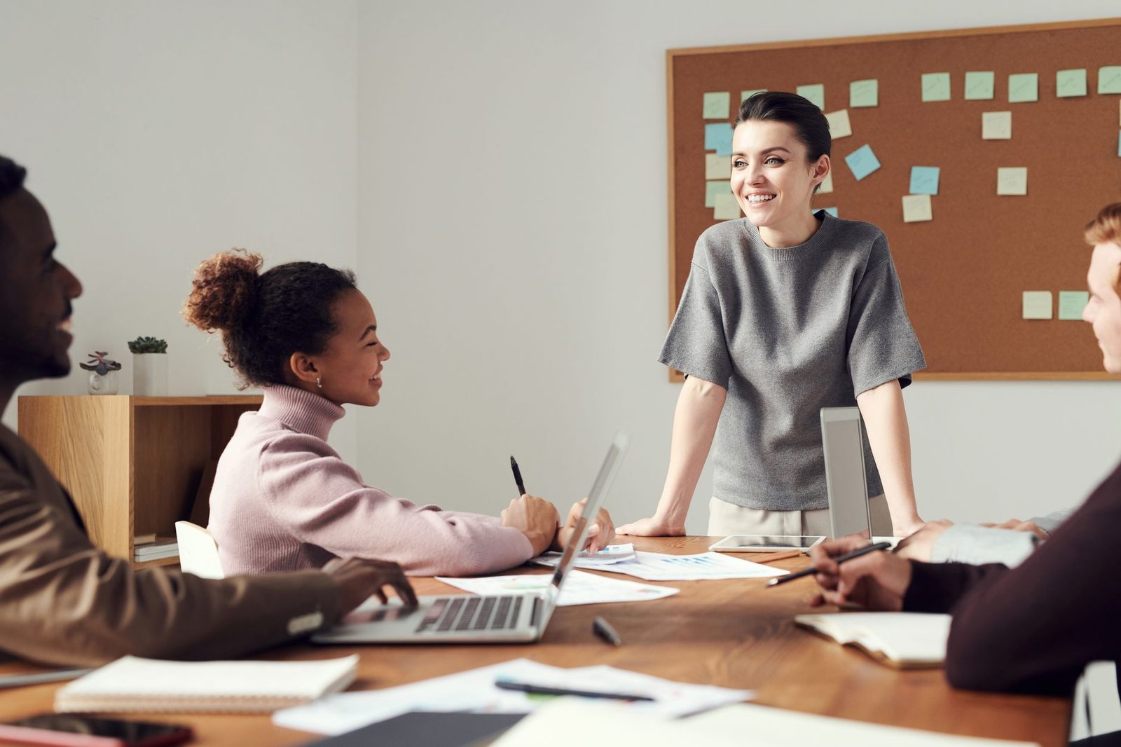 Jeunes collaborateurs réunis autour d'une table de bureau avec ordinateur portable et documents
