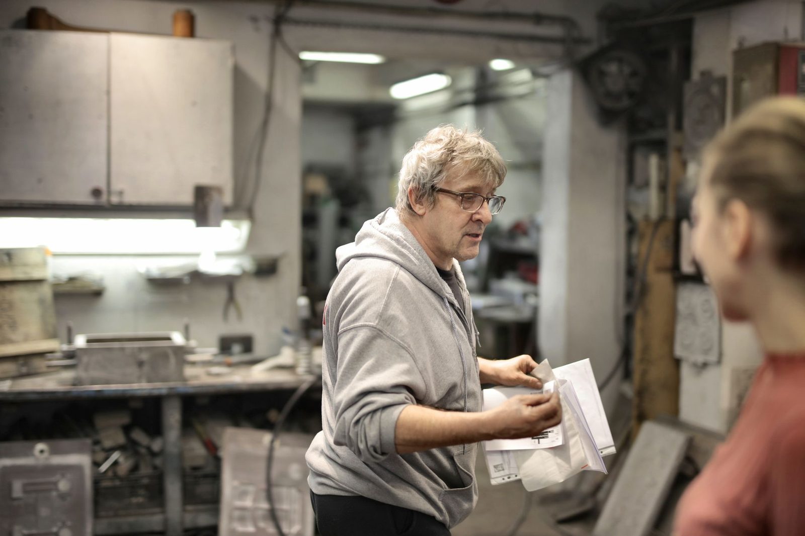 Un artisan expérimenté explique des documents à une jeune personne dans un atelier